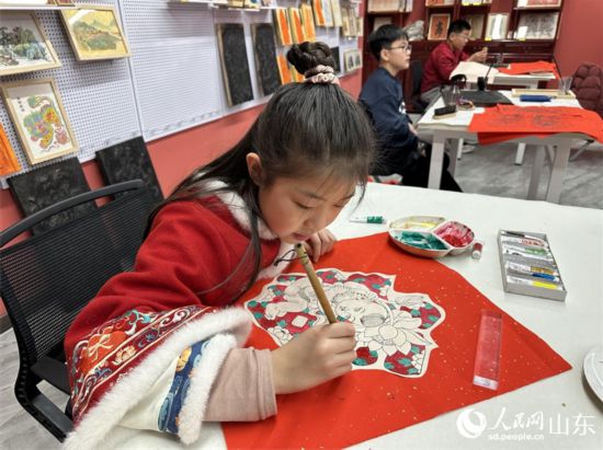 小學(xué)生在社教研學(xué)項(xiàng)目中給年畫填色。 人民網(wǎng) 喬姝攝
